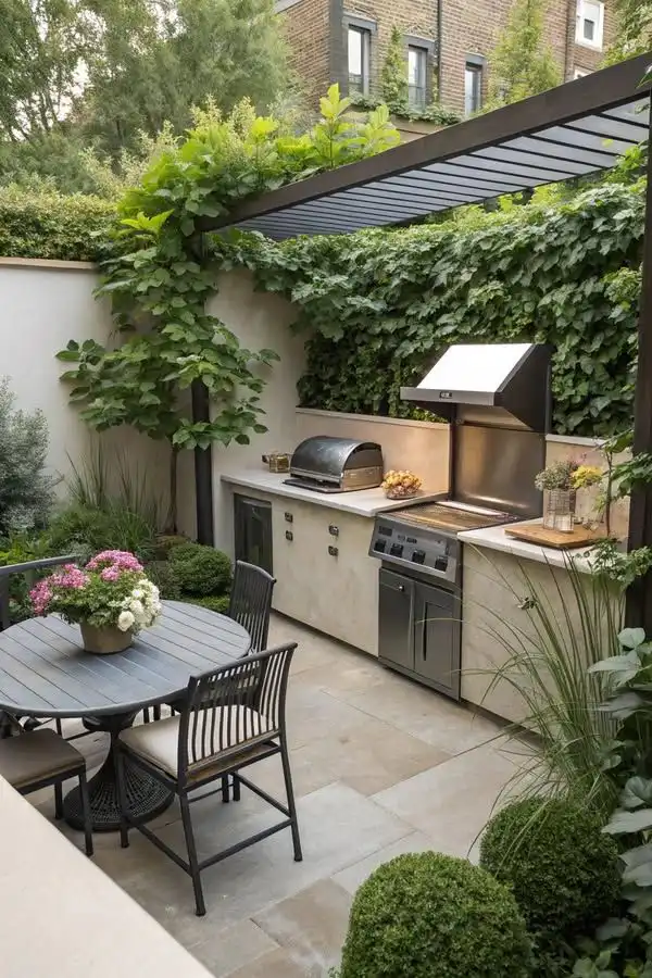 Outdoor patio kitchen with grill, stylish dining area, lush greenery, and pergola, blending elegance and functionality in