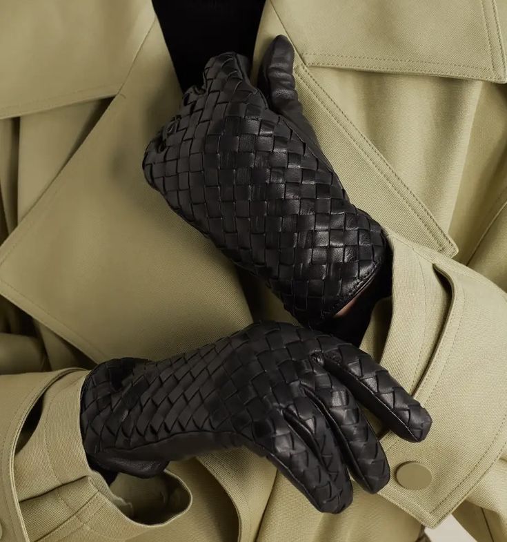 Woven black leather gloves on a beige trench coat, showcasing stylish and sophisticated winter fashion accessories for a polished look.