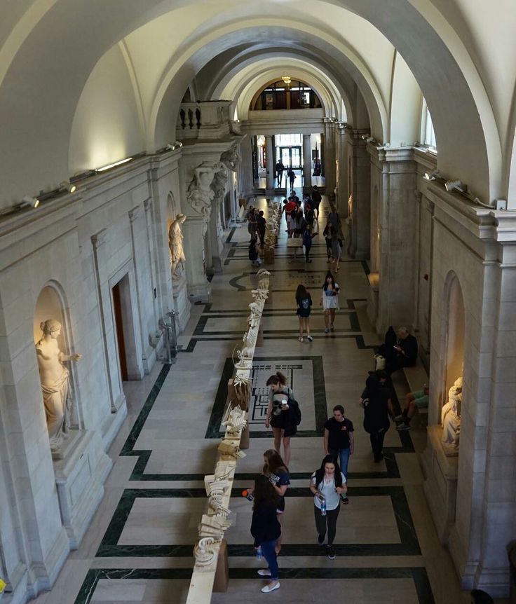 Carnegie Mellon Visitors exploring a museum hallway with classical sculptures and high arch ceilings, creating an atmosphere of art and history. | Sky Rye Design Visitors exploring a museum hallway with classical sculptures and high arch ceilings, creating an atmosphere of art and history.