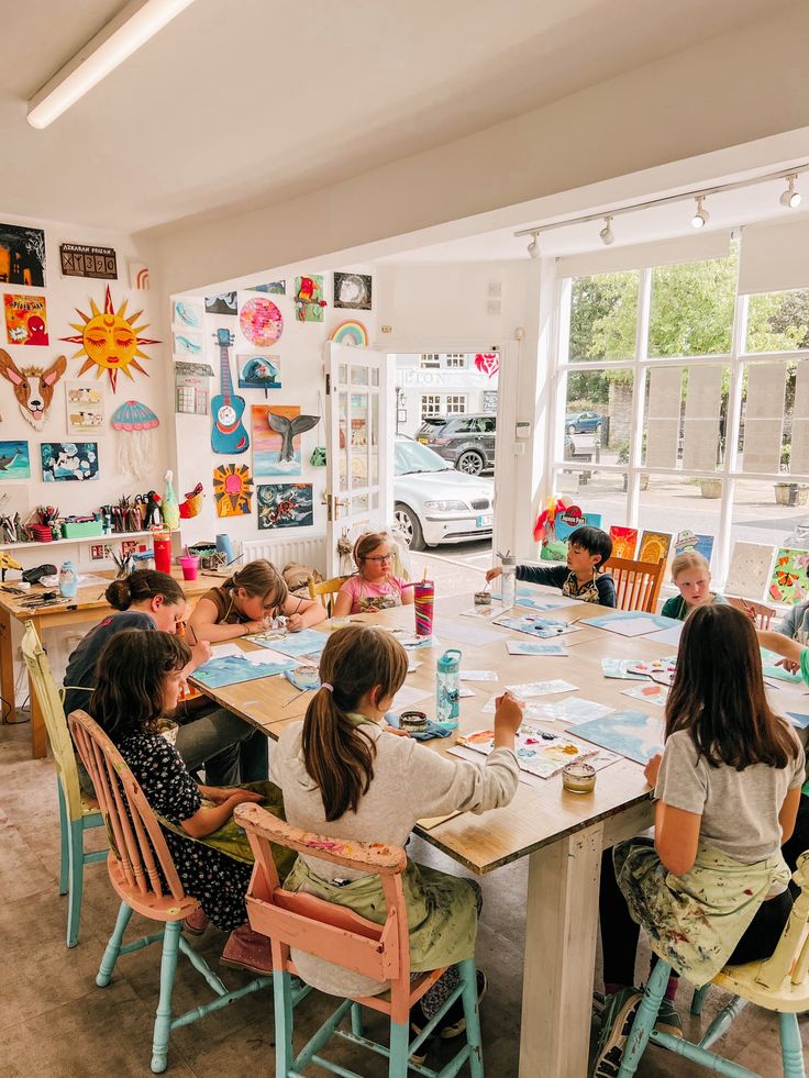 Childrens Art Lessons - Jessies Art Shed Children engaged in colorful art projects in a bright, creative classroom filled with paintings and natural light. | Sky Rye Design Children engaged in colorful art projects in a bright, creative classroom filled with paintings and natural light.