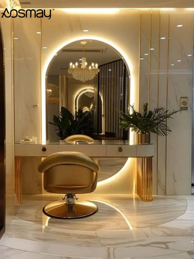 Luxurious salon interior with a stylish gold chair, illuminated mirror, marble flooring, and elegant chandelier, creating a modern ambiance.