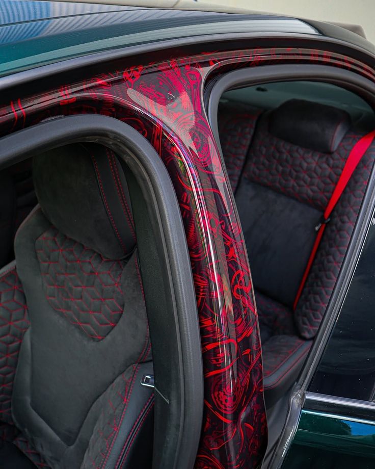 Discover Stunning Car Wrap Designs That Transform Your Ride Close-up of a car's interior with stylish red and black upholstery and custom decorative trim detailing on the door frame. | Sky Rye Design Close-up of a car's interior with stylish red and black upholstery and custom decorative trim detailing on the door frame.
