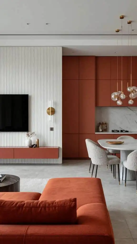Modern living room with red accents, featuring a sleek sofa, elegant dining area, pendant lights, and a wall-mounted TV for