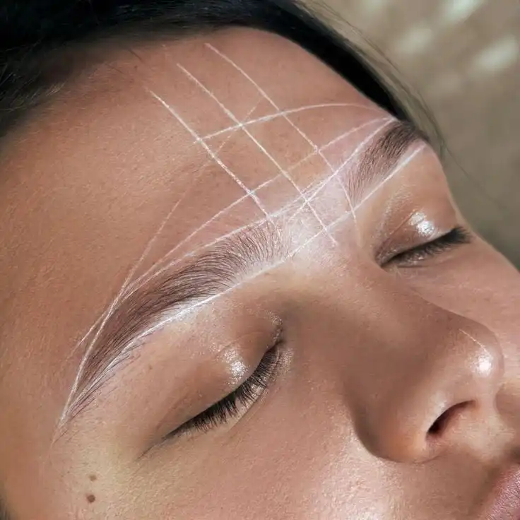 Eyebrow Mapping Course and Training Guide _ Printable Editable Canva Manual _ Brow Mapping Tutorial PDF _ PMU Brows Education Certificate Close-up of a person's forehead with mapping lines drawn for eyebrow shaping and microblading. | Sky Rye Design Close-up of a person's forehead with mapping lines drawn for eyebrow shaping and microblading.
