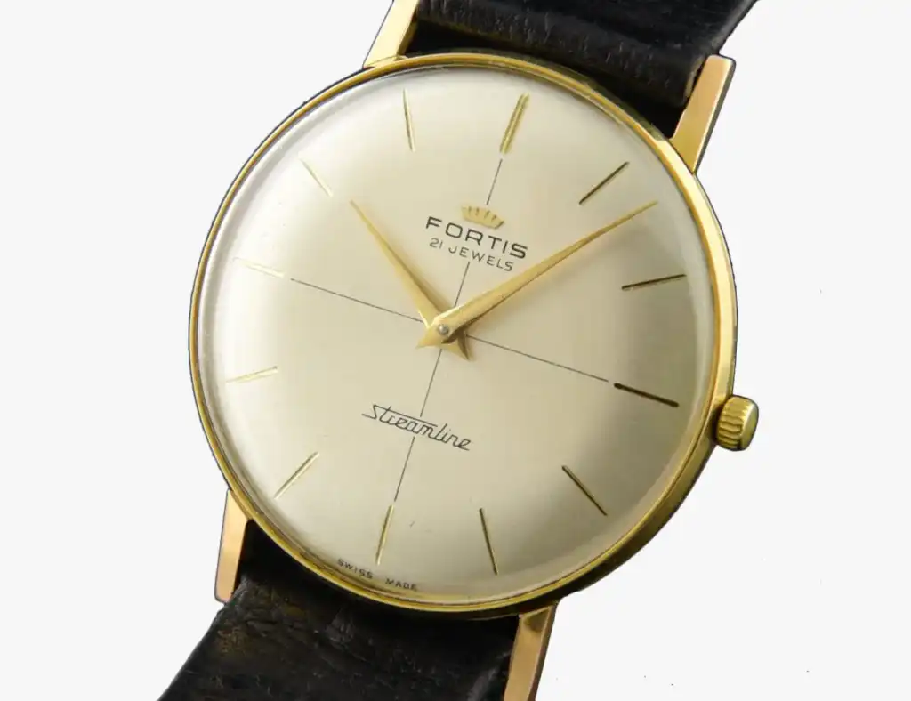 Vintage Fortis Streamline watch with a gold case, minimalist dial, and black leather strap, showcasing timeless elegance.