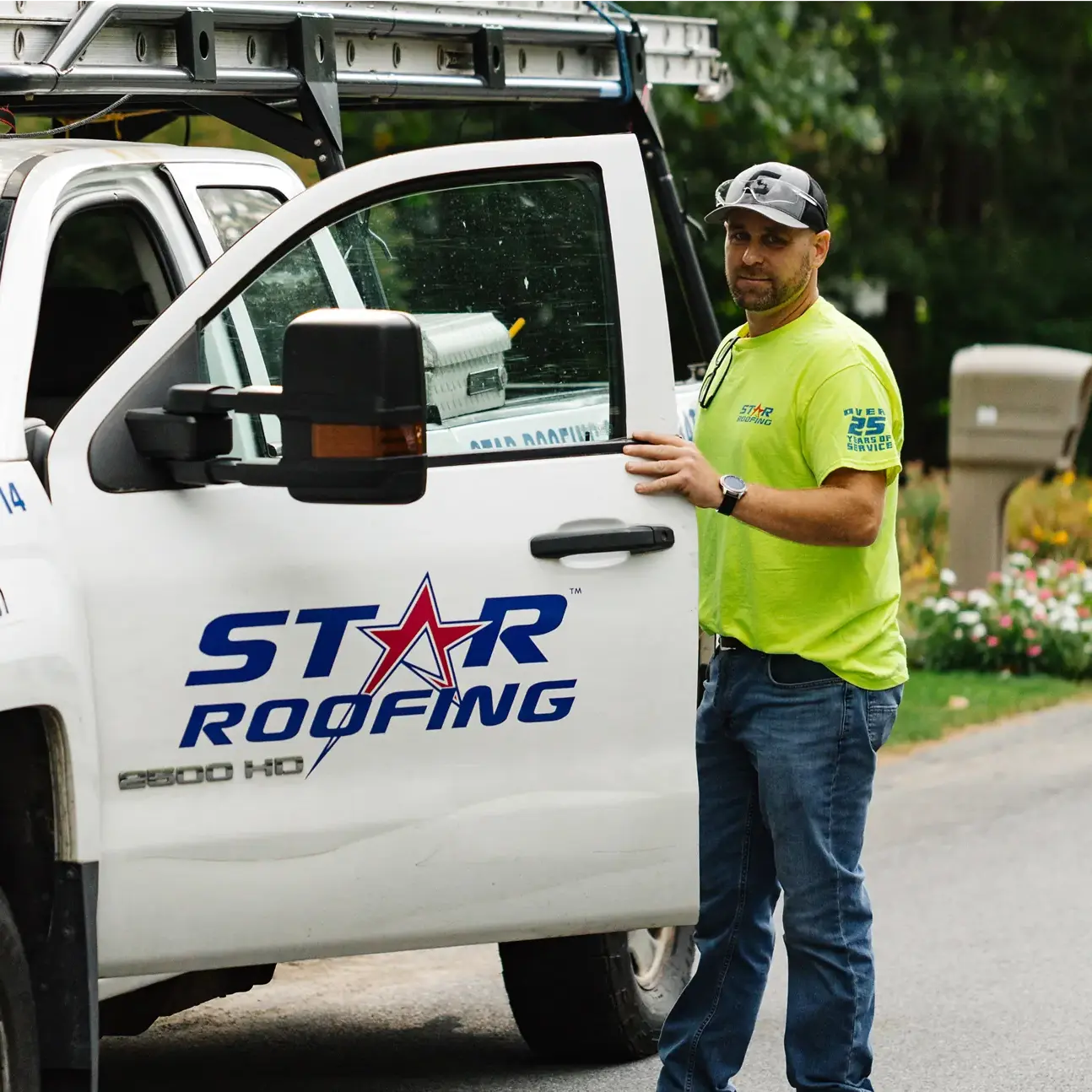 Group-20 Worker standing by a Star Roofing truck, ready for service, showcasing professional roofing services. | Sky Rye Design Worker standing by a Star Roofing truck, ready for service, showcasing professional roofing services.