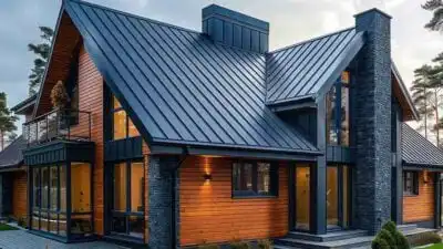 Modern wooden house with a sleek metal roof, large windows, and stone accents, set against a serene background of trees.