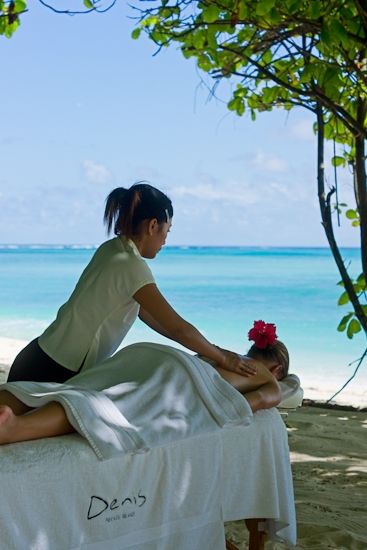 Indulge in some wellness massages at Denis Private island Beachside massage therapy on a tropical island with ocean view, serene relaxation under a tree canopy, perfect for unwinding and rejuvenation. | Sky Rye Design Beachside massage therapy on a tropical island with ocean view, serene relaxation under a tree canopy, perfect for unwinding and rejuvenation.