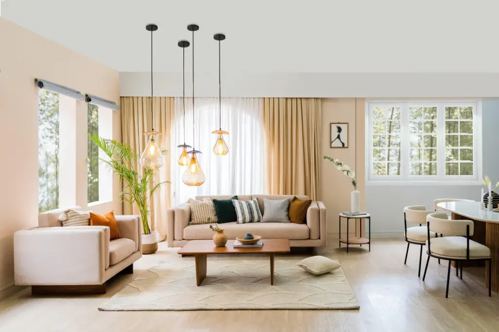 Living-and-dining_1_1_1100x Modern living room with beige sofas, pendant lights, large windows, and a wooden coffee table, creating a cozy and stylish atmosphere. | Sky Rye Design Modern living room with beige sofas, pendant lights, large windows, and a wooden coffee table, creating a cozy and stylish atmosphere.