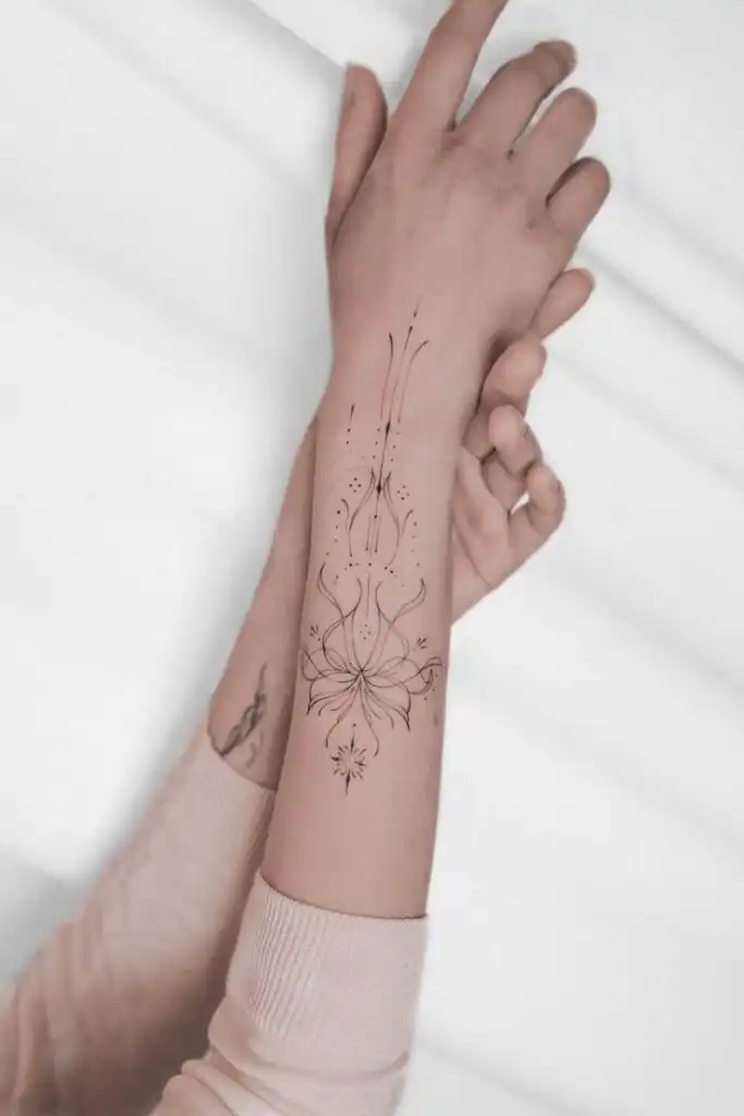 Elegant floral tattoo design on forearm, with intricate lines and symbols, showcased on a neutral background for aesthetic appeal.