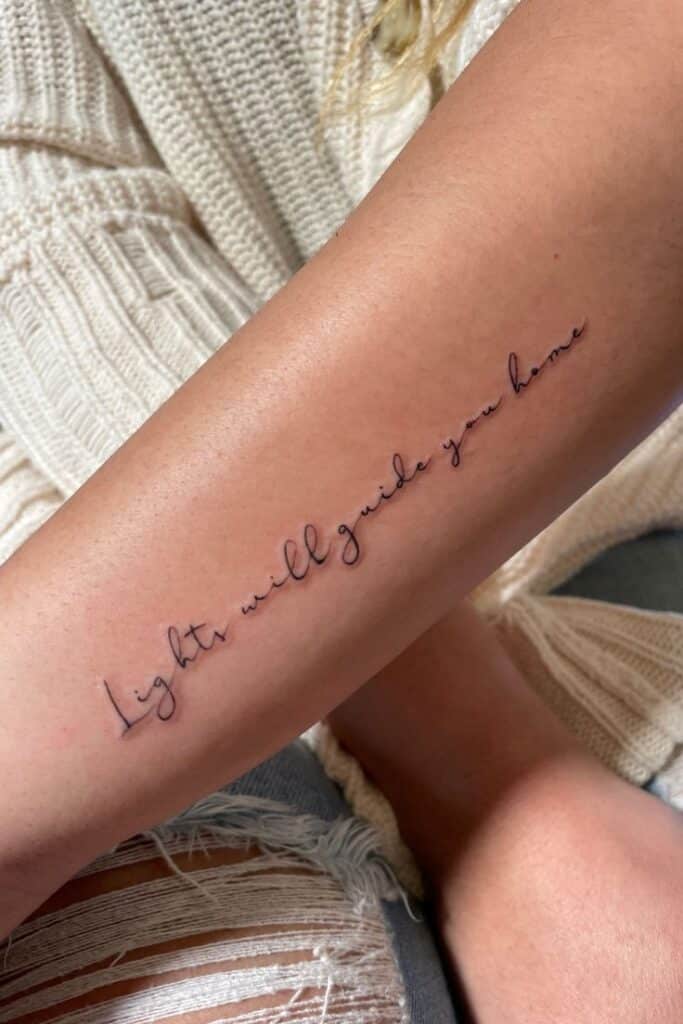 Minimal Script Tattoo _ Lights will guide you home Elegant script tattoo on arm reads Lights will guide you home, positioned in casual attire. | Sky Rye Design Elegant script tattoo on arm reads Lights will guide you home, positioned in casual attire.