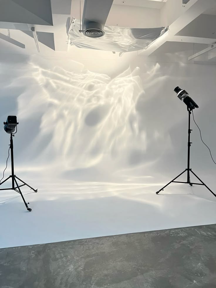 Mylar sheet Photography studio setup with lighting equipment casting dynamic reflections on a white backdrop, creating a creative visual effect. | Sky Rye Design Photography studio setup with lighting equipment casting dynamic reflections on a white backdrop, creating a creative visual effect.