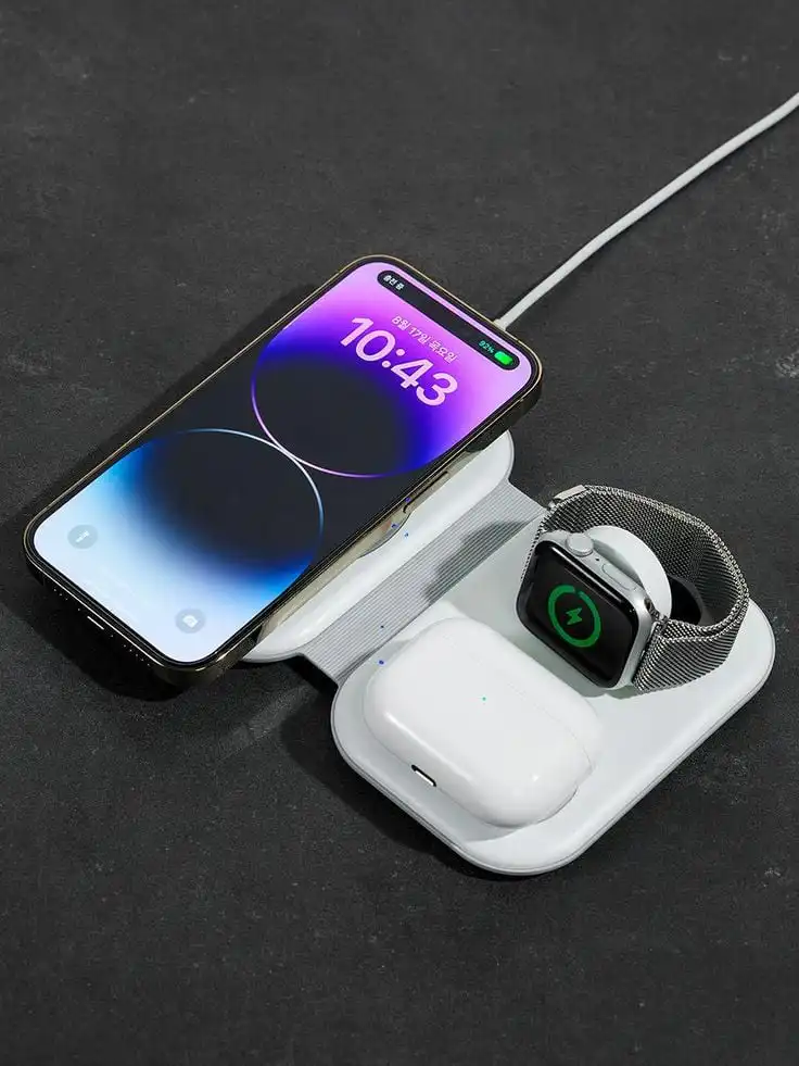 Wireless charging station with smartphone, smartwatch, and earbuds on a dark surface. Efficient multi-device charging solution.