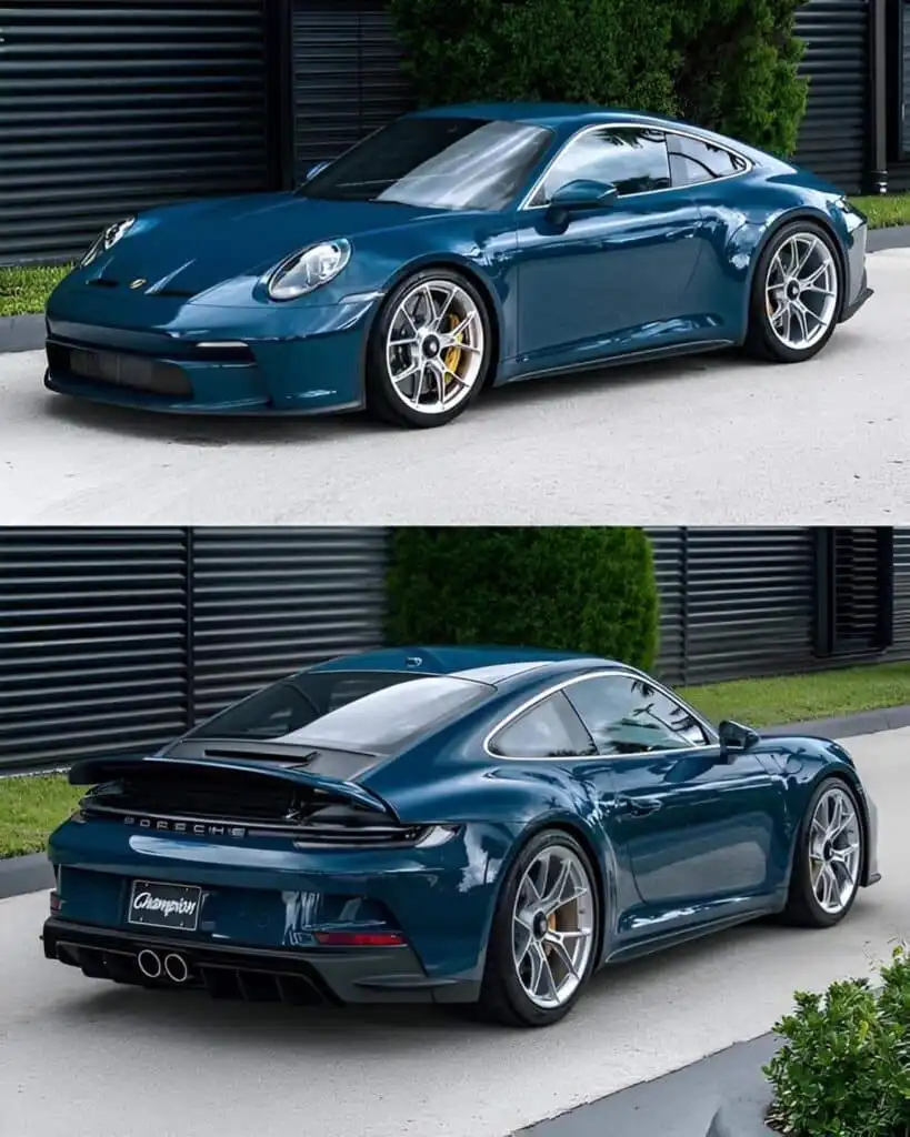 Sleek blue sports car showcasing modern design and alloy wheels, parked outside a stylish building with greenery in the
