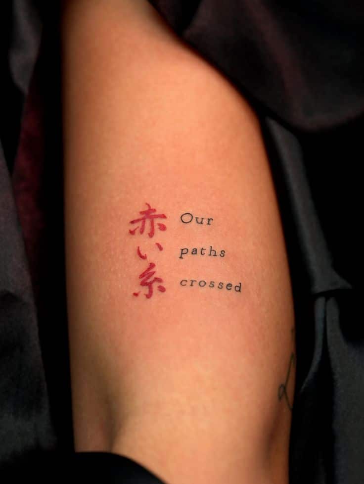 Recently finished fine line words and short Red and black tattoo on arm with Japanese characters and English text saying Our paths crossed, symbolizing fate and connection. | Sky Rye Design Red and black tattoo on arm with Japanese characters and English text saying Our paths crossed, symbolizing fate and connection.