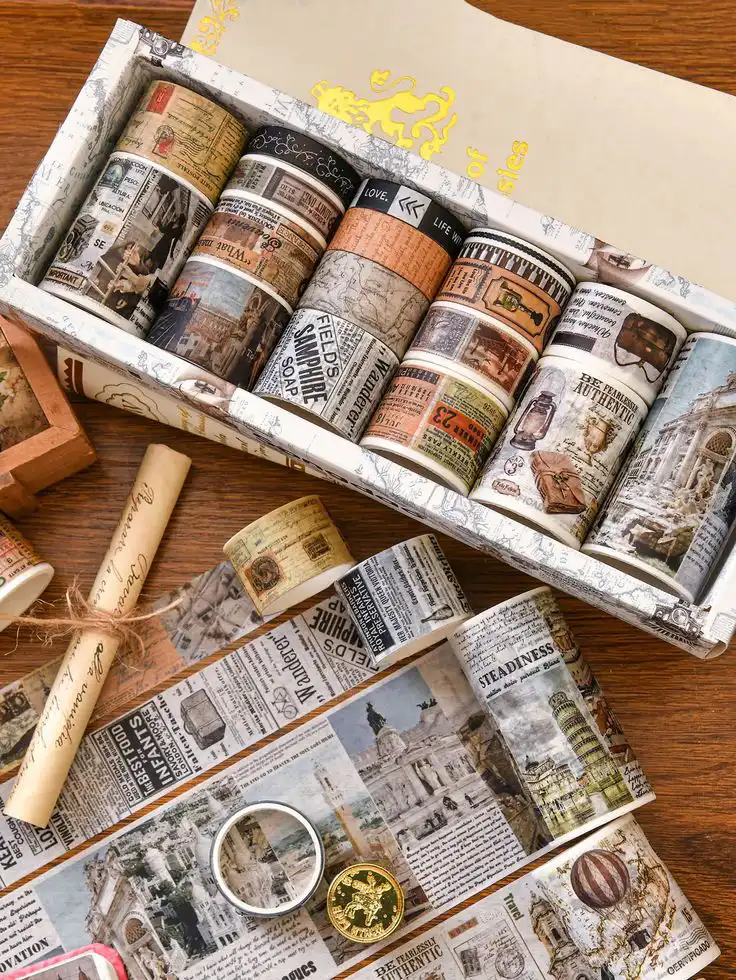 Decorative vintage-style washi tape set with historical, newspaper, and travel-themed designs displayed in a box on a wooden surface.