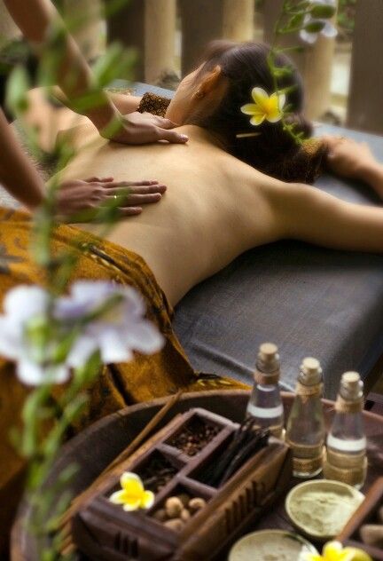 Spa Woman receiving a relaxing back massage in a spa setting, surrounded by nature-inspired decor, aromatic oils, and fresh flowers. | Sky Rye Design Woman receiving a relaxing back massage in a spa setting, surrounded by nature-inspired decor, aromatic oils, and fresh flowers.