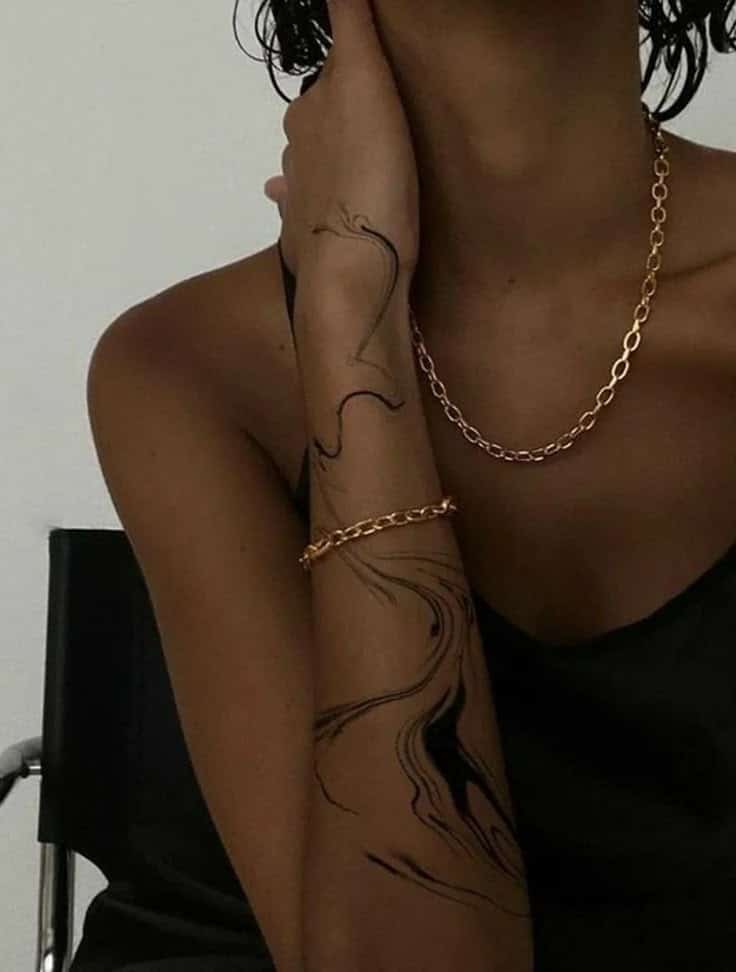 Tatuagem de signo_ Saiba qual é a perfeita para você STEAL THE LOOK Elegant gold chain complements abstract arm tattoo design in a modern, stylish setting. Ideal for jewelry and tattoo inspiration themes. | Sky Rye Design Elegant gold chain complements abstract arm tattoo design in a modern, stylish setting. Ideal for jewelry and tattoo inspiration themes.