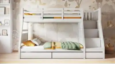 White bunk bed with built-in stairs and storage, featuring green and yellow bedding in a cozy kids' room with whimsical