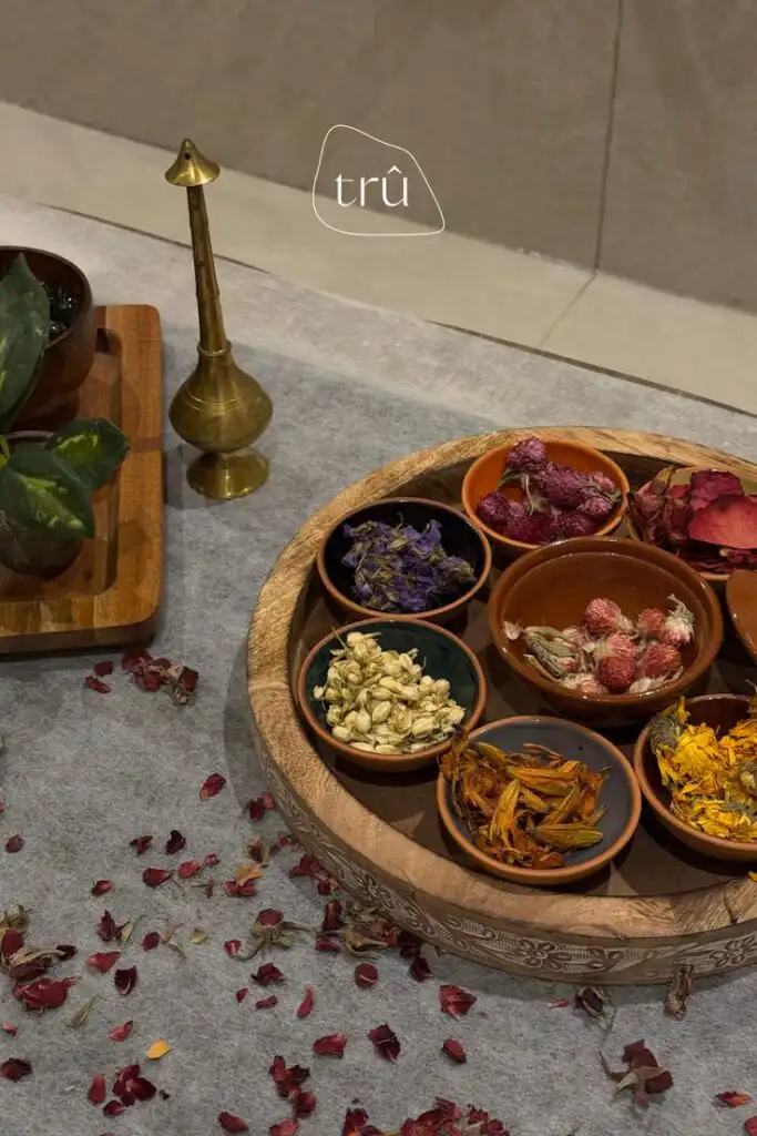 Assorted dried botanicals in bowls on carved wooden tray, ideal for natural decor or herbal crafts. Includes petals and leaves.