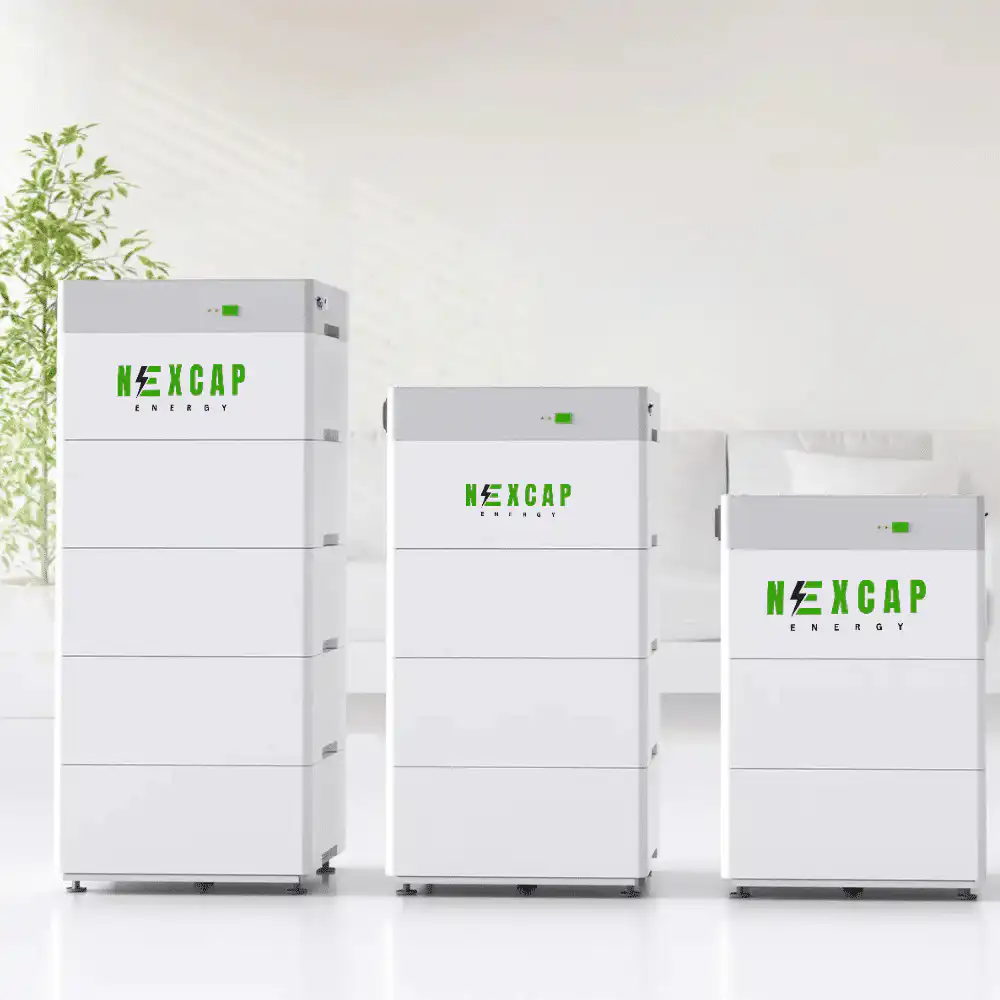 Three sleek white storage units from Nexcap Energy in a minimalistic room with natural light and a leafy plant.