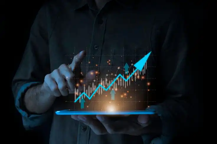 Person holding a tablet with a rising graph, symbolizing financial growth and analytics, enhanced by digital effects.