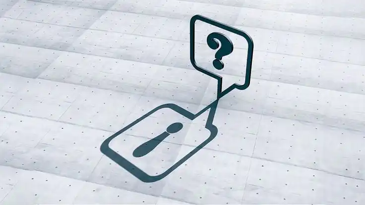 Information icon casting a shadow of a question mark on a concrete surface, symbolizing inquiry and understanding.