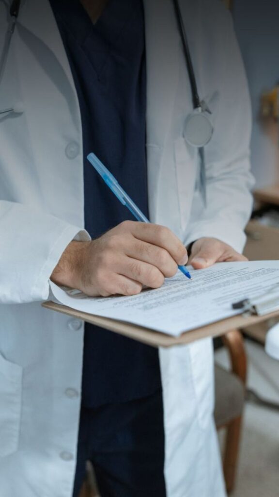 a doctor have been many chance to save a human been Doctor in white coat writing on a clipboard in an office setting, emphasizing medical professionalism and patient care documentation. | Sky Rye Design Doctor in white coat writing on a clipboard in an office setting, emphasizing medical professionalism and patient care documentation.