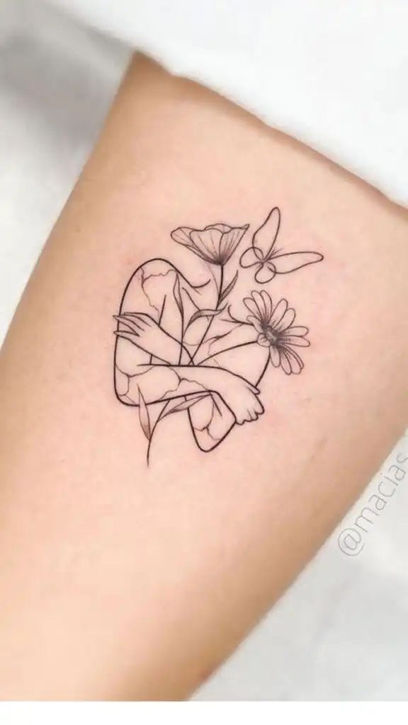 Minimalist tattoo of a heart with flowers and a butterfly on the arm, symbolizing love and nature's harmony. Tattoo Ideas About Self-Love