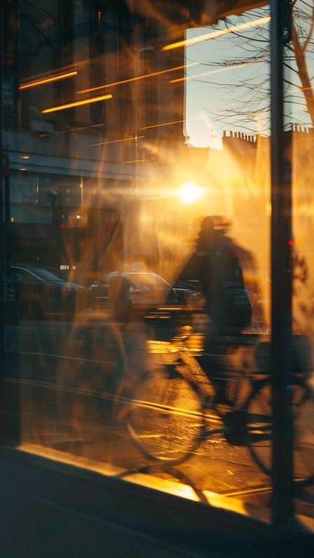 bc094f45-2bf6-4e83-95af-05be9723538c Reflection of a cyclist riding past a window during a golden sunset, capturing urban life and evening light in a cityscape setting. | Sky Rye Design Reflection of a cyclist riding past a window during a golden sunset, capturing urban life and evening light in a cityscape setting.