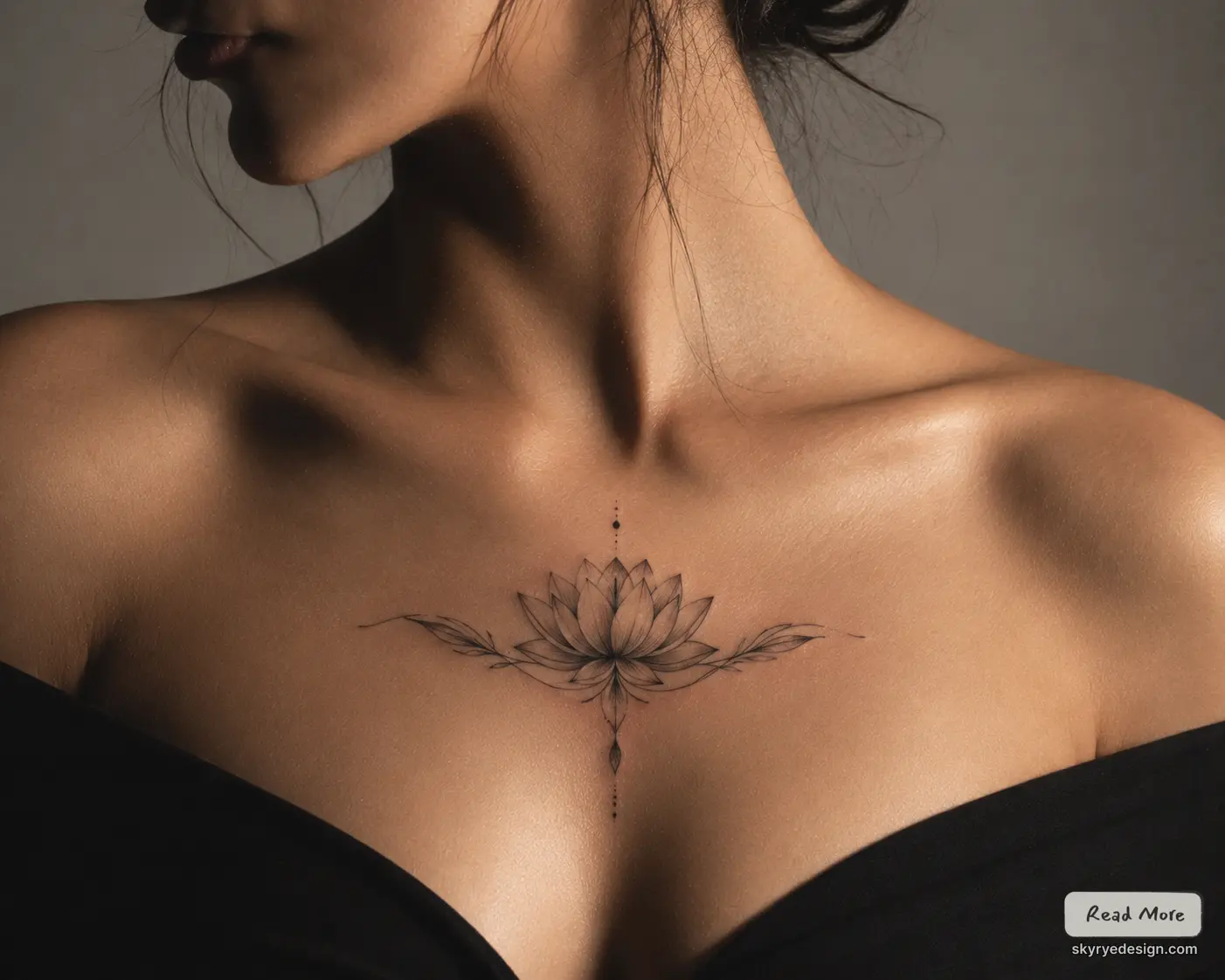 Close-up of a woman's bare shoulders and neck with a delicate lotus tattoo at the base of the neck across the upper chest.