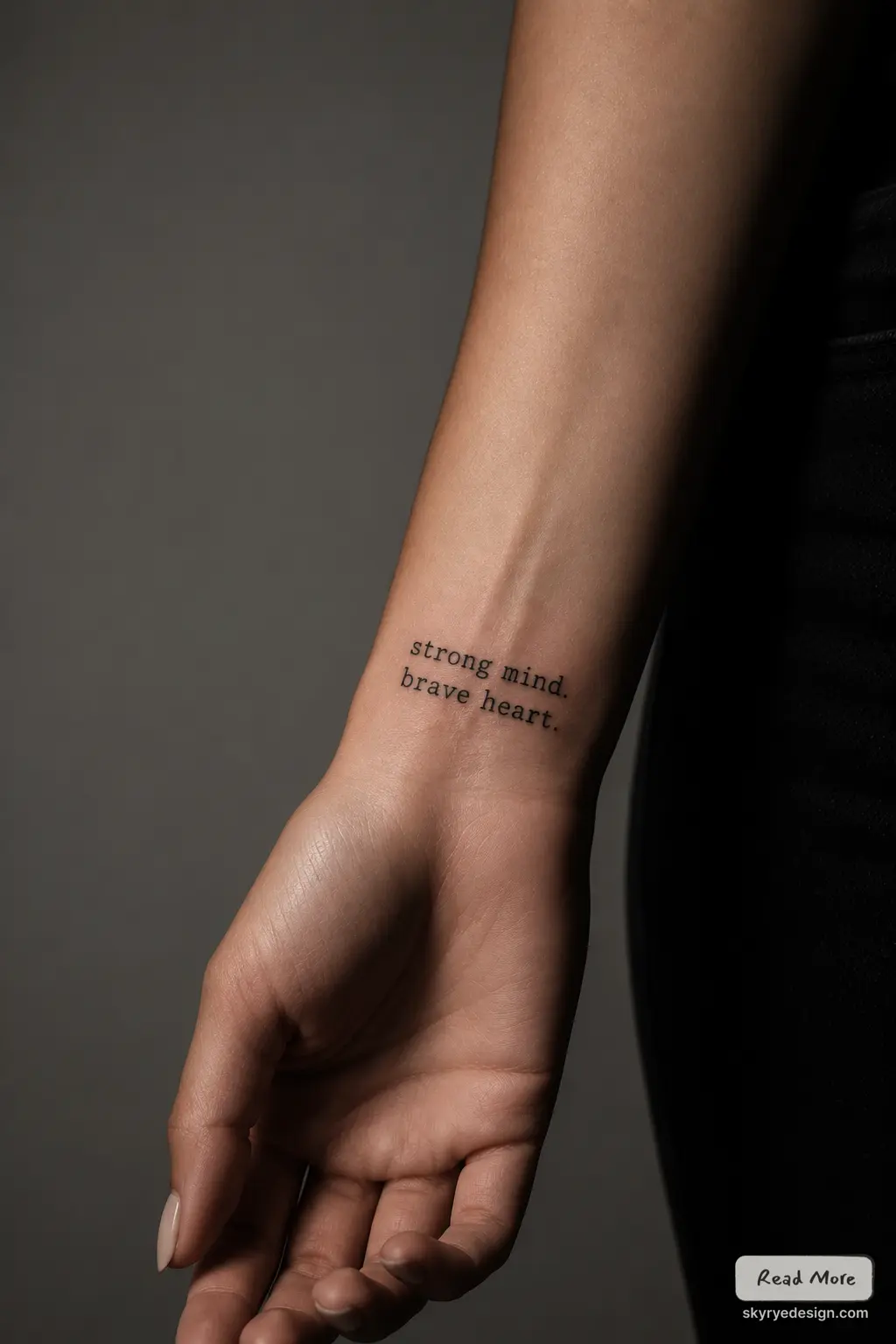 Close-up forearm/wrist tattoo of minimalist inspirational quote strong mind. brave heart. in small black typewriter font