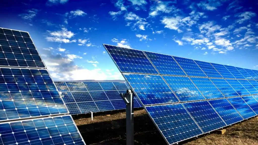 Solar panels under a clear blue sky, generating renewable energy and promoting sustainability in a field setting.