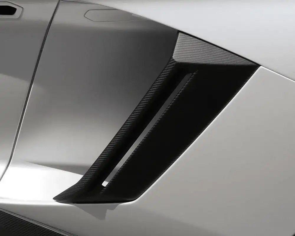 Close-up of a sports car's carbon fiber side air intake vent, highlighting its sleek and aerodynamic design, in metallic