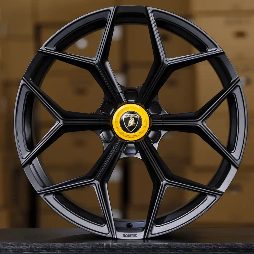 Sleek black alloy car wheel with intricate design and a yellow center cap, ideal for enhancing vehicle aesthetics and