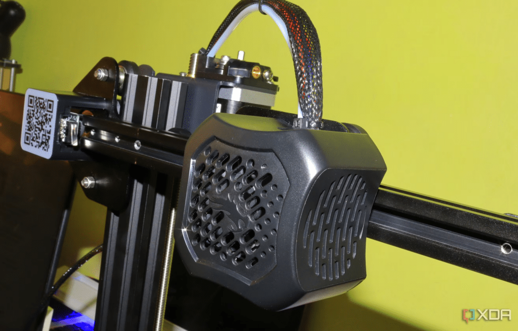 image Close-up of a 3D printer extruder on a Creality Ender 3 S1 against a green background. | Sky Rye Design Close-up of a 3D printer extruder on a Creality Ender 3 S1 against a green background.