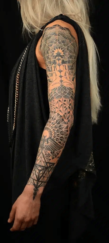 image Detailed sleeve tattoo on a person's arm with intricate geometric and abstract designs, showcasing artistic skill on a black background. | Sky Rye Design Detailed sleeve tattoo on a person's arm with intricate geometric and abstract designs, showcasing artistic skill on a black background.