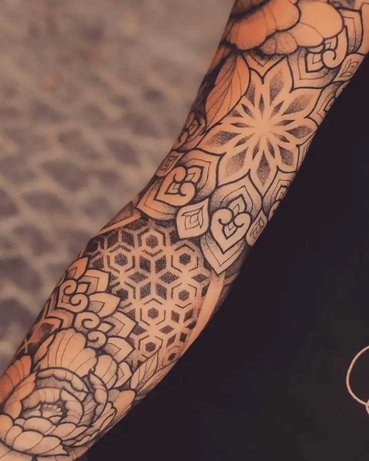 image Intricate geometric and floral tattoo sleeve showcasing detailed patterns and bold lines on an arm. | Sky Rye Design Intricate geometric and floral tattoo sleeve showcasing detailed patterns and bold lines on an arm.