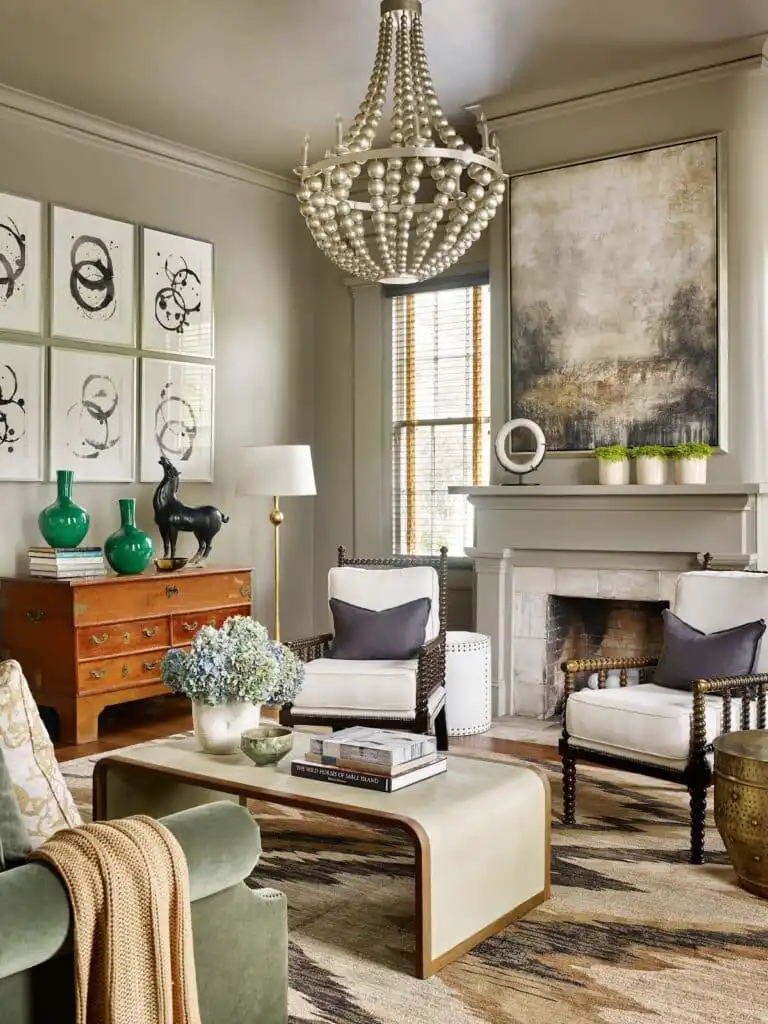 Elegant living room with a beaded chandelier, art pieces, vintage furniture, and cozy seating, creating a sophisticated and