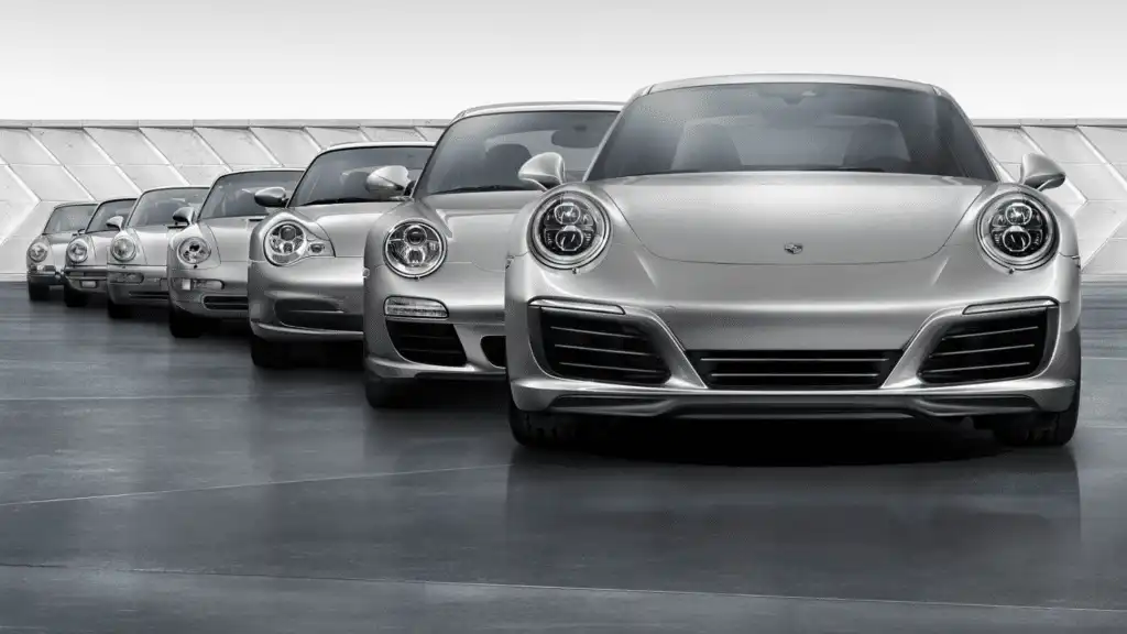 Lineup of classic and modern silver sports cars showcasing sleek design evolution on a smooth surface.