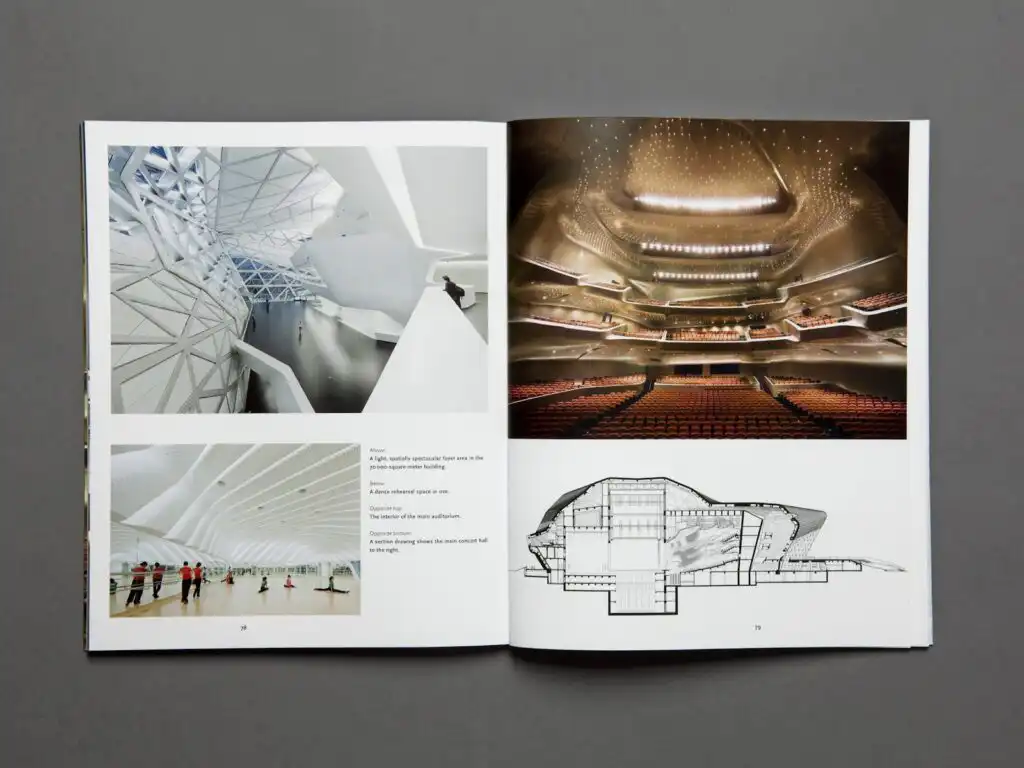 Open book displaying architectural images and diagrams, showcasing a modern concert hall interior and a spacious geometric