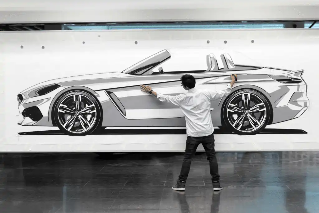 Designer analyzing a large car sketch, focusing on modern vehicle aesthetics and innovative automotive design.