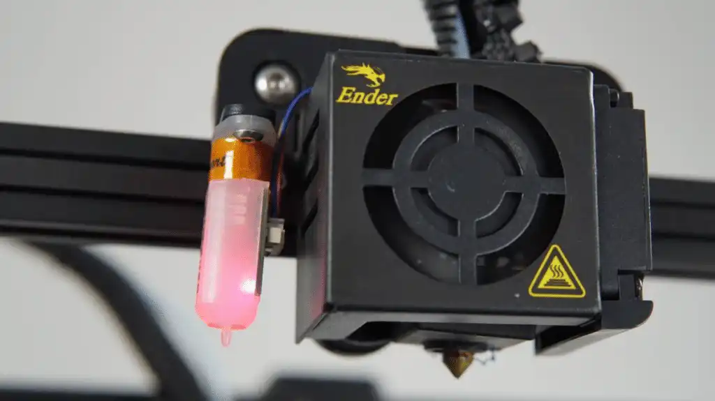 Close-up of an Ender 3D printer component with a glowing red LED light attachment, showcasing precision technology in action.