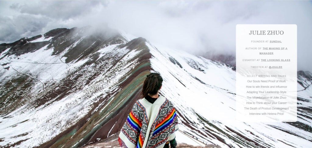Person in colorful poncho gazes at snowy Rainbow Mountain landscape with featured writings of Julie Zhuo displayed on the