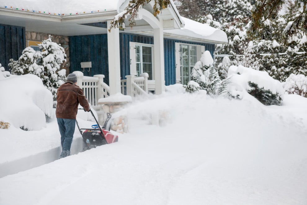 _ Person using a snow blower to clear a driveway in front of a snow-covered house. Winter weather, snow removal, and outdoor | Sky Rye Design Person using a snow blower to clear a driveway in front of a snow-covered house. Winter weather, snow removal, and outdoor