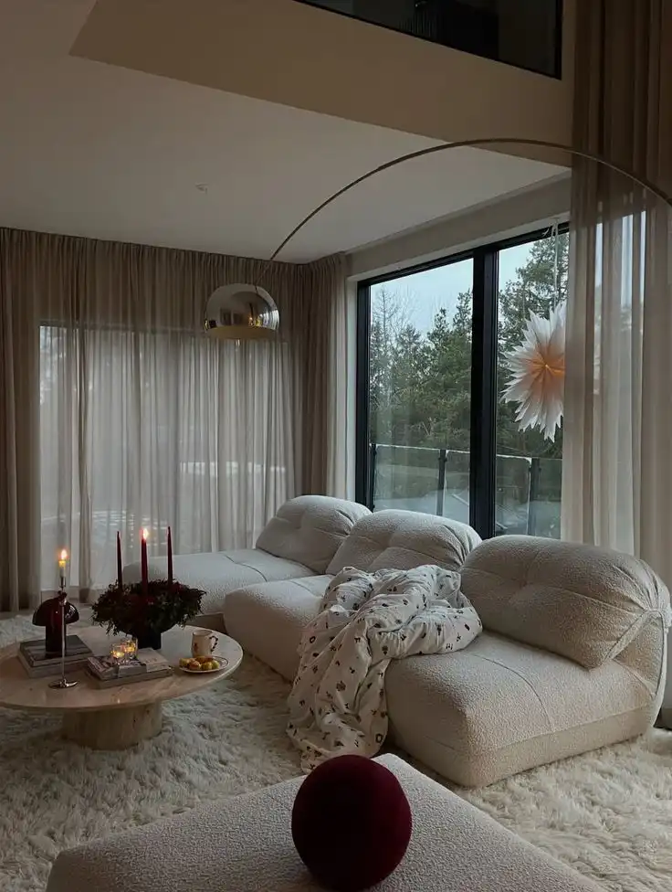 ИГ_ 34kvadrat Modern cozy living room with plush sofa, soft lighting, and elegant decor. Large windows reveal a serene outdoor view. | Sky Rye Design Modern cozy living room with plush sofa, soft lighting, and elegant decor. Large windows reveal a serene outdoor view.