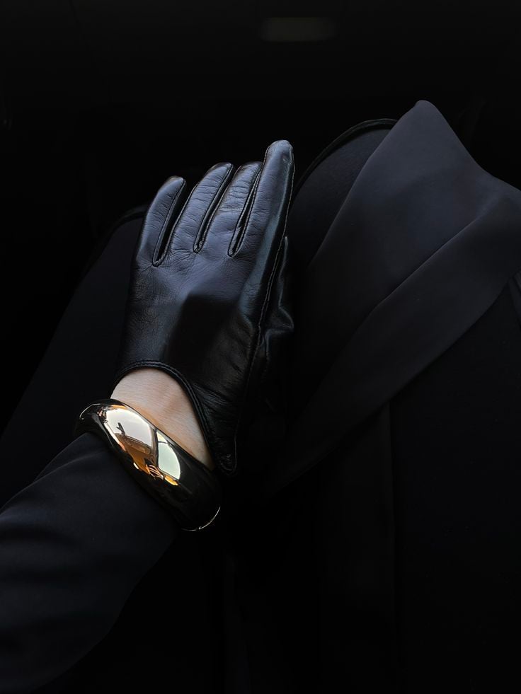 Эстетика идеи для фото идеи контента ootd fashion женственный стиль аксессуары Elegant black leather glove rests on lap with a shiny gold bracelet, reflecting light in a dark, sophisticated setting. | Sky Rye Design Elegant black leather glove rests on lap with a shiny gold bracelet, reflecting light in a dark, sophisticated setting.