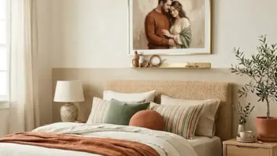 Cozy neutral bedroom with textured headboard, layered linen bedding, rust throw, striped pillows and potted plant