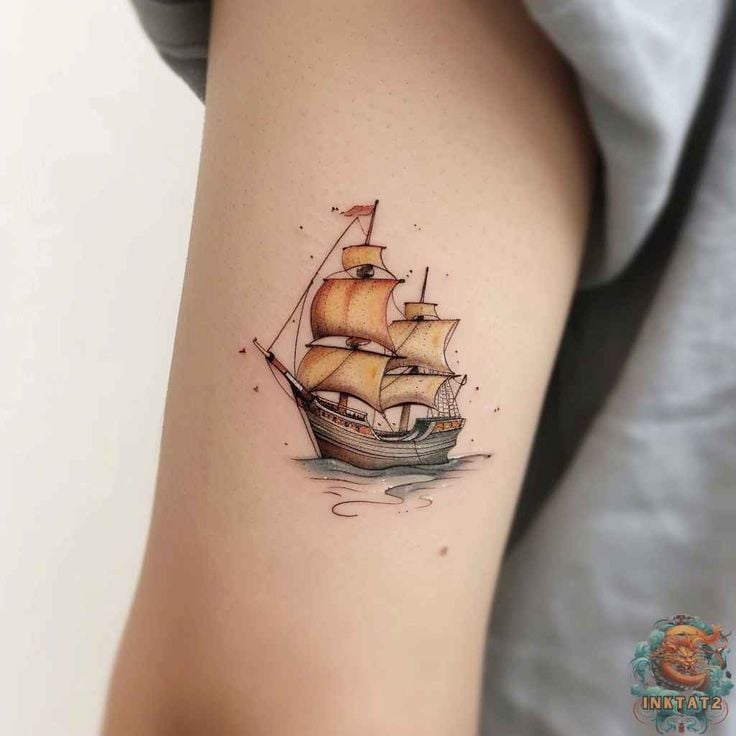 Small colorful vintage sailing ship tattoo with billowing sails, fine-line detail and subtle watercolor on inner upper arm