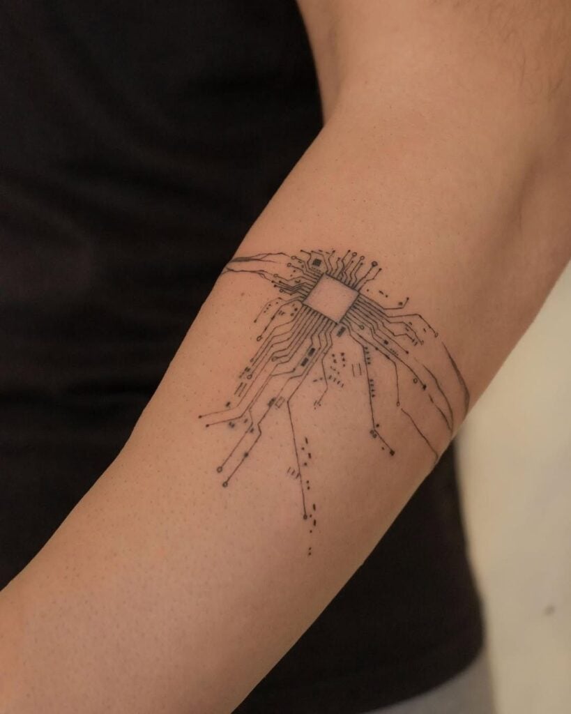 Minimal black microchip and circuit board tattoo on inner forearm, tech-inspired minimalist electronics design